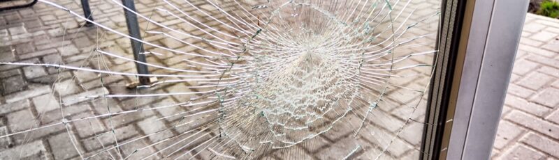 A,Close-up,Of,Shattered,Glass,Door,Window,With,A,Spiderweb