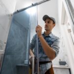 Workers,Are,Installing,Glass,Door,Of,The,Shower,Enclosure.