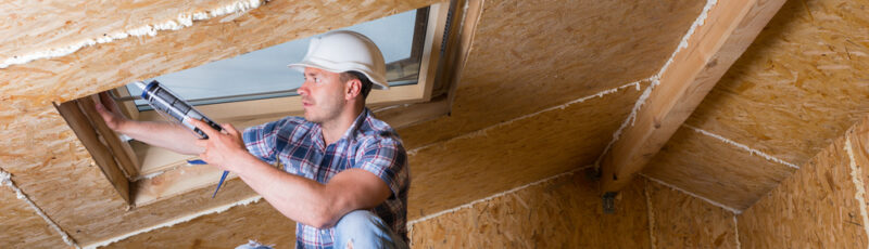 Male,Construction,Worker,Builder,Applying,Fresh,Caulking,To,Sky,Light