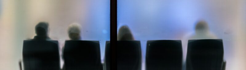 Silhouettes,Of,People,Sitting,In,A,Waiting,Room,With,Frosted